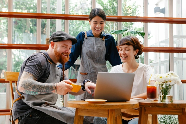 Baristas smiling at the computer screen